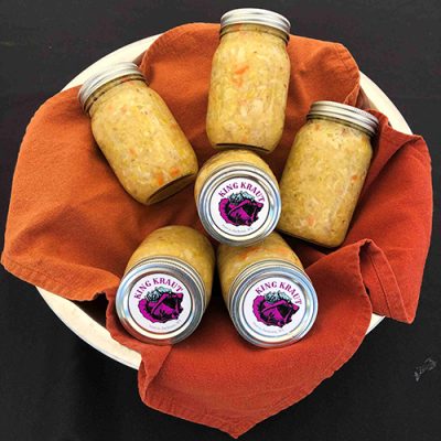 Jars of King Kraut sauerkraut on an orange cloth